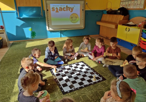 Dzieci oglądają planszę do gry w szachy